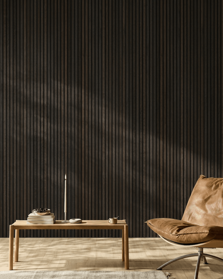 Pièce minimaliste avec un fauteuil en cuir brown, une table basse et des objets déco devant un mur en panneaux acoustiques en bois WoodUpp Akupanel Rustic Smoked Oak.