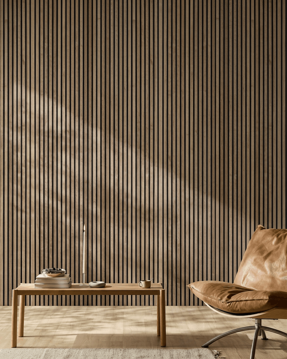 Pièce nordique minimaliste avec panneau acoustique en bois WoodUpp Akupanel en noyer, fauteuil en cuir fauve et table basse en bois avec des livres et une bougie.
